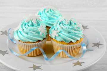 Few tasty blue cupcakes with decorations on light background