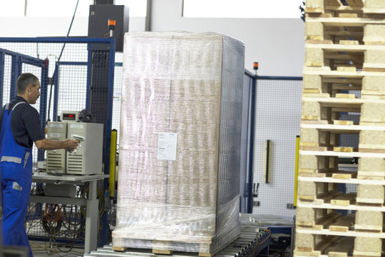 Worker using machine in paper packaging factory