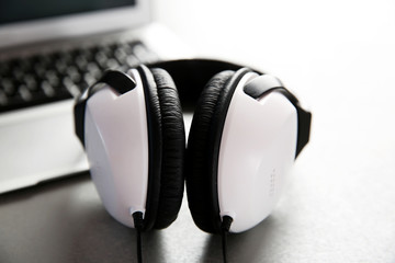 Obraz na płótnie Canvas Headphones and laptop on table closeup
