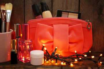 Beautician with brushes and cosmetics on wooden background