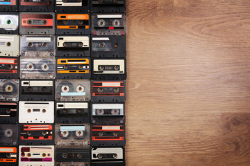 Collection of audio cassettes on wooden table background