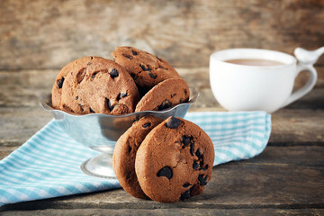 Chocolate chip cookies in a metal bowl on wooden table