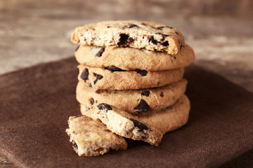 Chocolate chip cookies on a brown napkin on wooden table