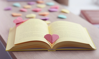 Books and heart shaped bookmarks on a wooden table