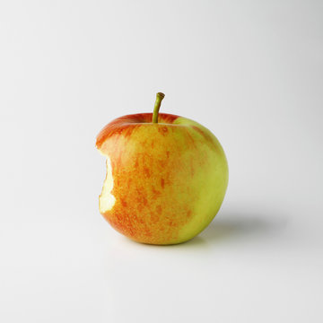 One apple on white background with bite mark