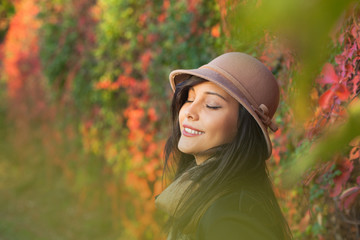 Beautiful woman posing and laughing. Autumn and spring portrait of beauty female model with flowers bouquet near a floral wall