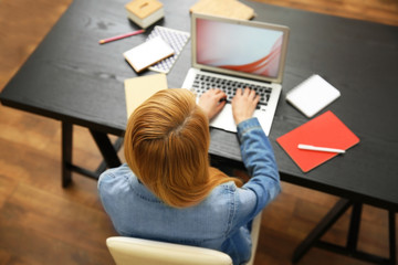 Woman working on a laptop at office desk