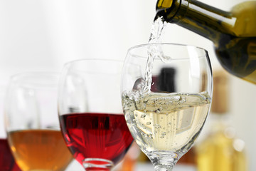 White wine pouring into glasses, closeup