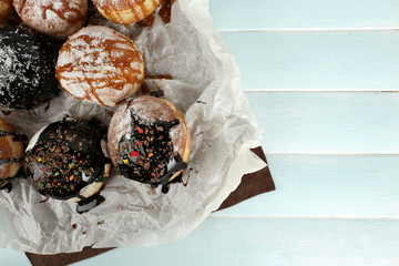 Delicious donuts icing with chocolate on parchment closeup