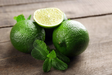 Limes with mint on wooden table