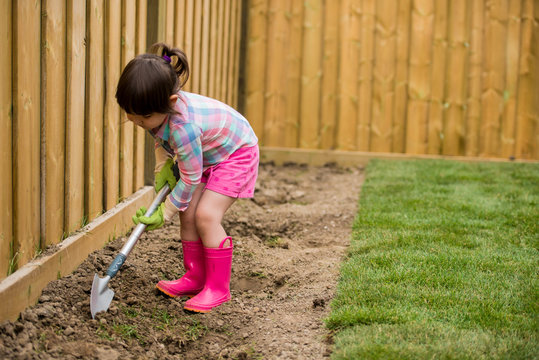 Young girl digging in the garden
