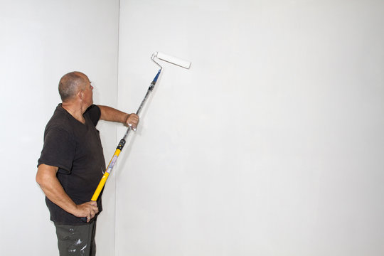 Studio shot of senior roller painting room walls