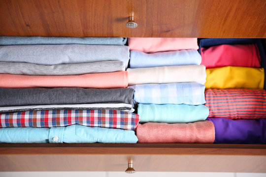 Neatly Folded Clothes In Wooden Drawer