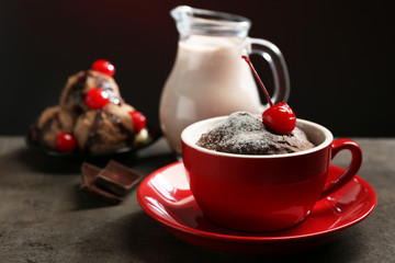 Chocolate cake in a red mug  with a cherry on top, close up