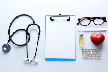 Doctor table with medicines, stethoscope and glasses, top view