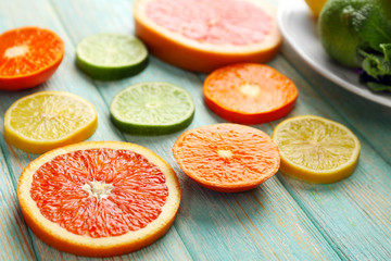 Juicy composition of citrus fruits on wooden background, close up