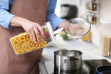 Man cooking pasta in kitchen