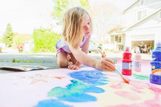 Girl painting with tempera on paper