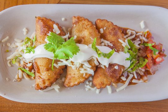 Aruban food, pastries with sauce and garnish on plate