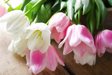 Bouquet of pink and white tulips on wooden background