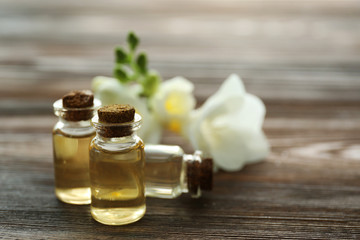 Beautiful flower, aroma oil and candles on wooden background