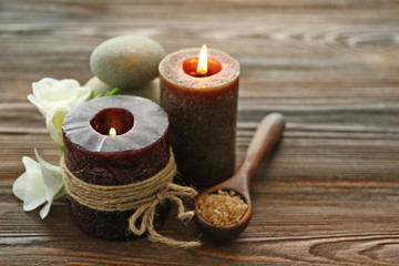 Fototapeta na wymiar Spa set with sea salt, flowers and candles on wooden background