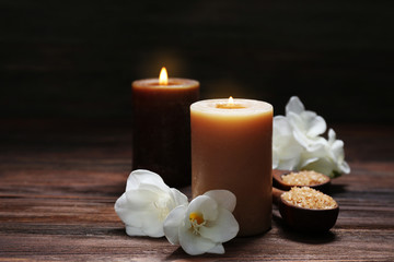 Fototapeta na wymiar Spa set with sea salt, exotic flowers and candles on wooden background