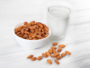 Cup of milk and almond nuts on table
