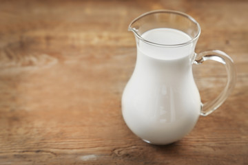 Jug of milk on wooden table