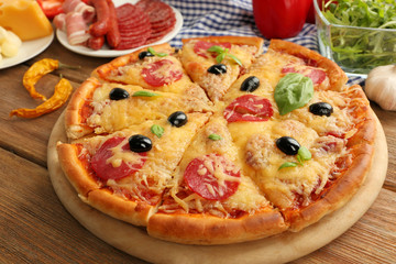 Fresh baked pizza on a wooden table, close up