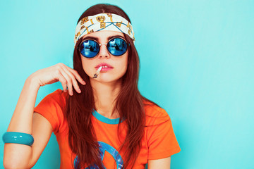 Piękny hipis dziewczyna portret palenia i noszenie okularów przeciwsłonecznych - 106934344