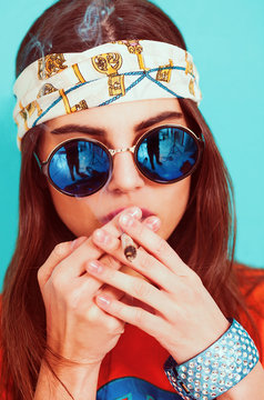 Hippie girl smoking weed and wearing sunglasses
