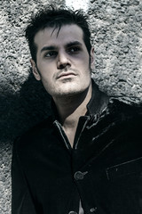 Obraz premium Handsome man portrait standing by a wall