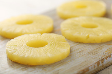 Rings of pineapple on wooden cutting board closeup