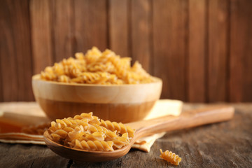Raw pasta on wooden background