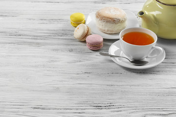 Cup of tea with delicious cake and macaroons