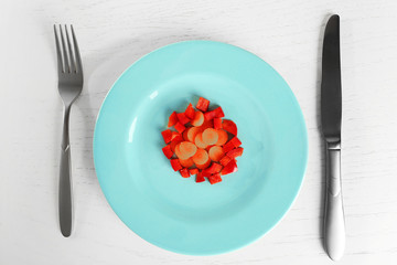 Plate served with carrots and peppers on white wooden table