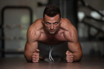 Obraz na płótnie Canvas Bodybuilder Doing Push Ups On Floor