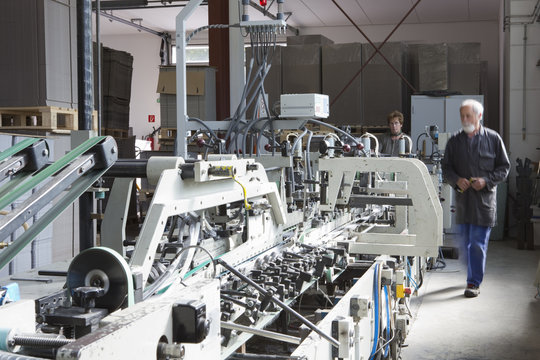 Factory workers machine in cardboard factory