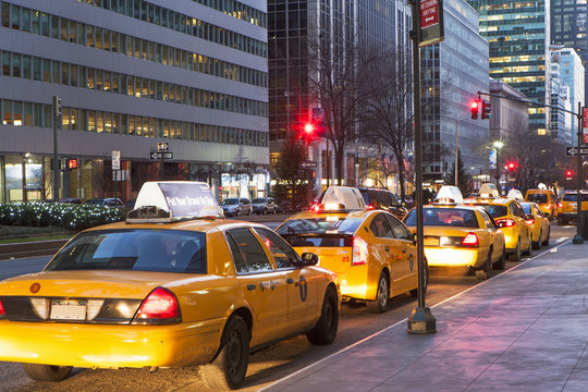 Row of yellow cabs next to sidewalk, New York, USA