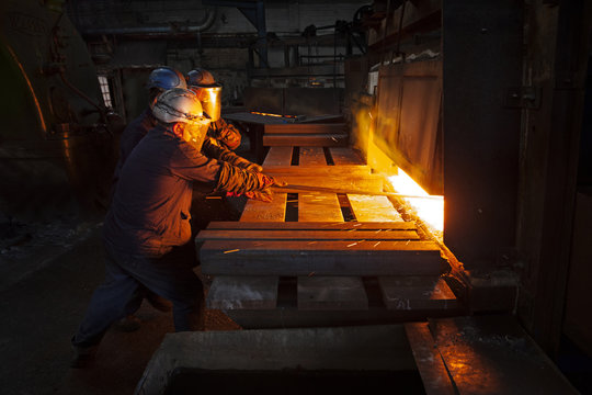 100mm square steel billet is removed from furnace as cold steel billet waits in foreground to be heated