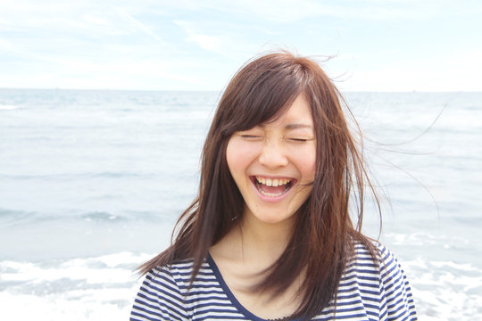 Portrait of young woman with eyes closed, laughing