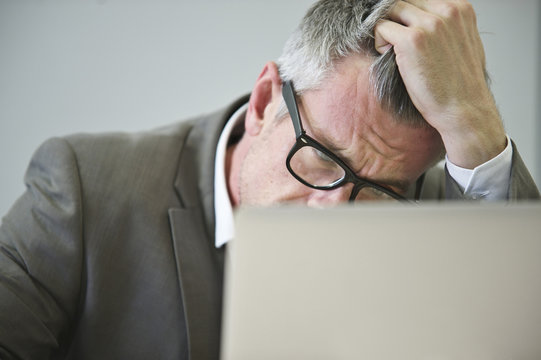 Stressed mature businessman in office