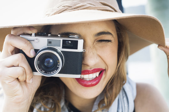 Close up of glamorous young woman holding up film camera
