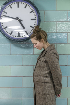 Pregnant woman by clock
