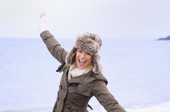 Mid adult woman having fun on beach, Thurlestone, Devon, UK