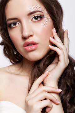 Close-up portrait of young woman with face art  make up and mani