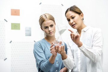Female colleagues discussing workings of the hourglass