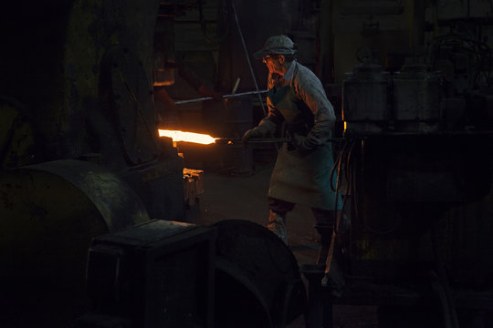Inserting red hot steel billet into upset forge