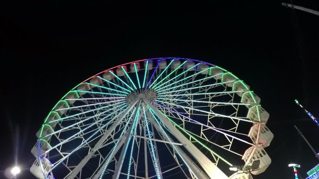 Ferris Wheel slowmotion in amusement park at night.